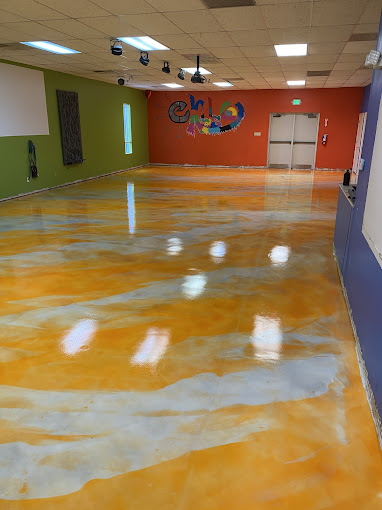 Gold and silver metallic epoxy floor in a commercial room with colorful painted walls